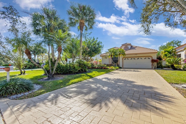 mediterranean / spanish-style home with a garage and a front lawn