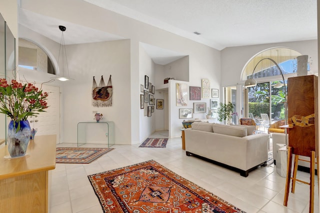 tiled living room featuring high vaulted ceiling and a textured ceiling