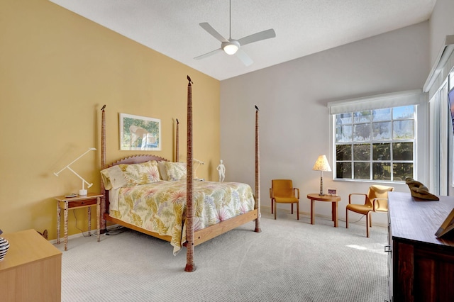 bedroom with vaulted ceiling, carpet floors, a textured ceiling, and ceiling fan