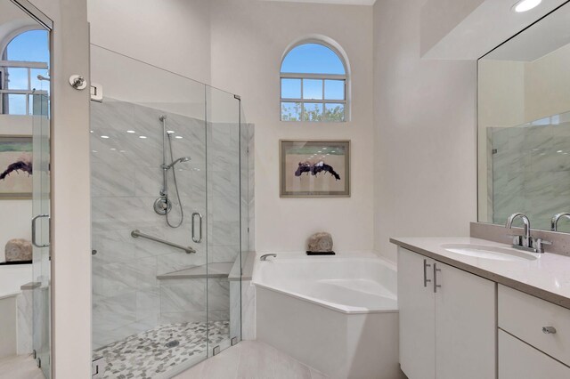 bathroom with vanity and shower with separate bathtub