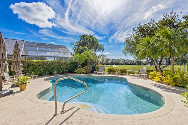 view of pool with a patio and glass enclosure