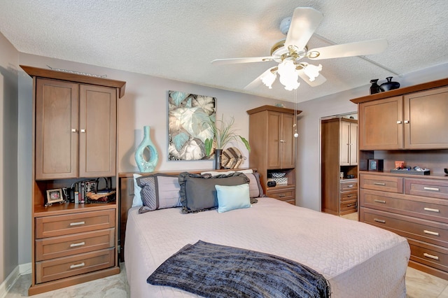 bedroom with ceiling fan and a textured ceiling