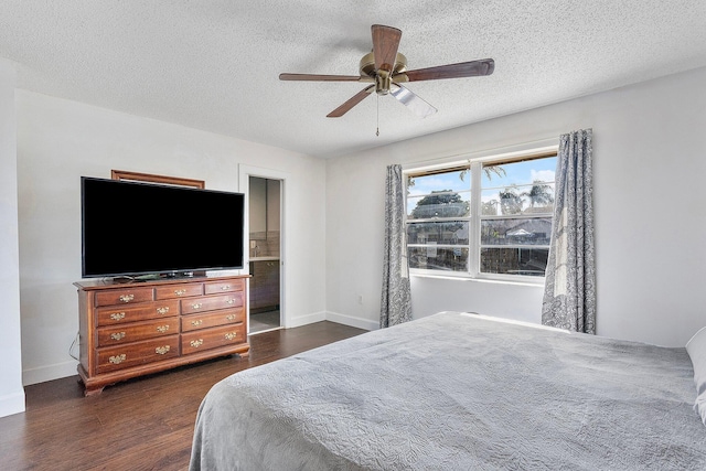 bedroom featuring ceiling fan, dark wood-type flooring, and a textured ceiling