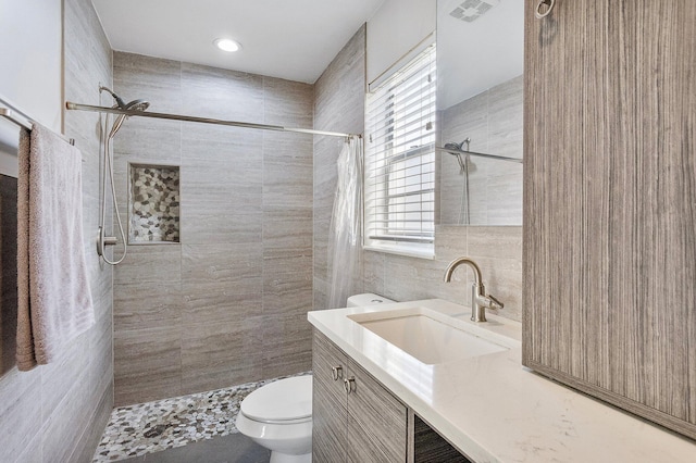 bathroom with vanity, toilet, tile walls, and a shower with curtain