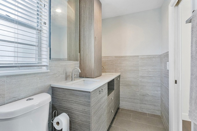 bathroom featuring tile walls, vanity, tile patterned floors, and toilet