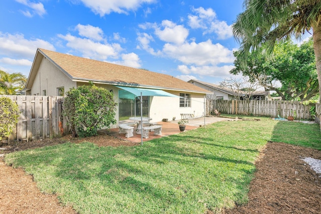 rear view of property with a yard and a patio area