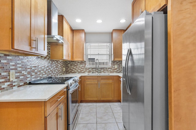 kitchen featuring appliances with stainless steel finishes, sink, decorative backsplash, light tile patterned floors, and wall chimney exhaust hood