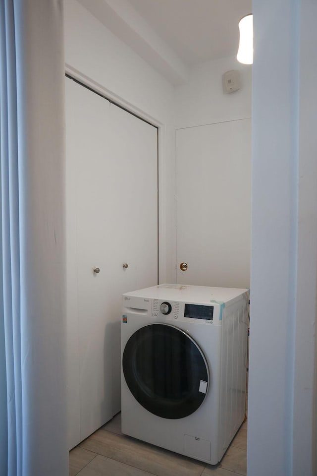 laundry area featuring washer / dryer and light hardwood / wood-style flooring