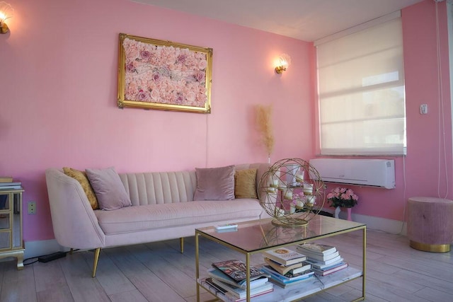 living room with a wall mounted air conditioner and light hardwood / wood-style flooring