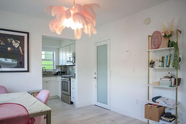 interior space with an inviting chandelier, sink, and light hardwood / wood-style flooring