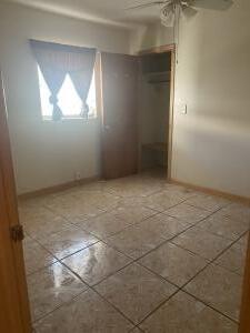 unfurnished bedroom featuring ceiling fan and a closet