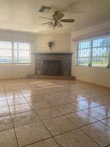 unfurnished living room with a tiled fireplace, tile patterned flooring, and ceiling fan