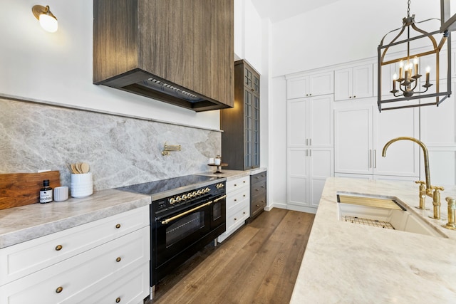 kitchen with premium range hood, sink, white cabinets, and double oven range