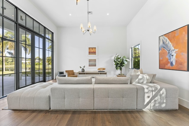 living room featuring a healthy amount of sunlight, wood-type flooring, and a high ceiling