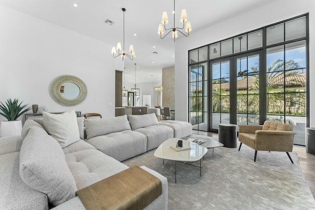 living room with light hardwood / wood-style floors, a high ceiling, and a notable chandelier