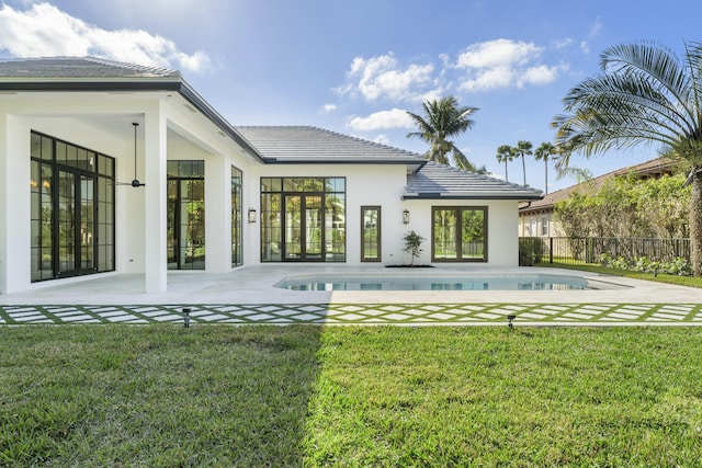 back of property with a yard and a patio area