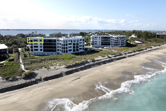 birds eye view of property featuring a water view and a beach view