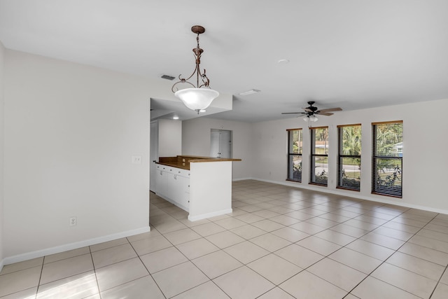 kitchen with butcher block counters, light tile patterned floors, decorative light fixtures, and ceiling fan