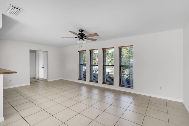 tiled empty room featuring ceiling fan