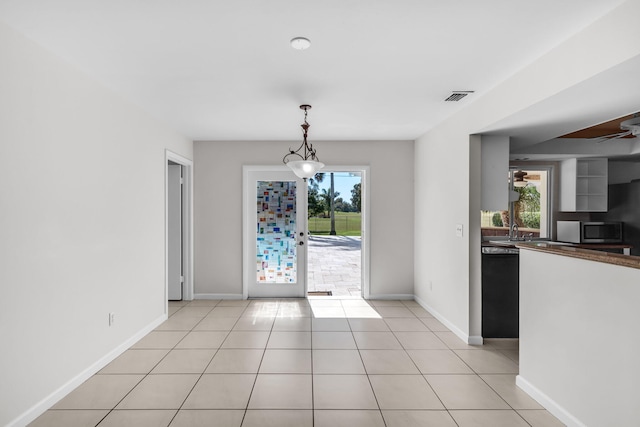 unfurnished dining area featuring sink, plenty of natural light, and light tile patterned flooring