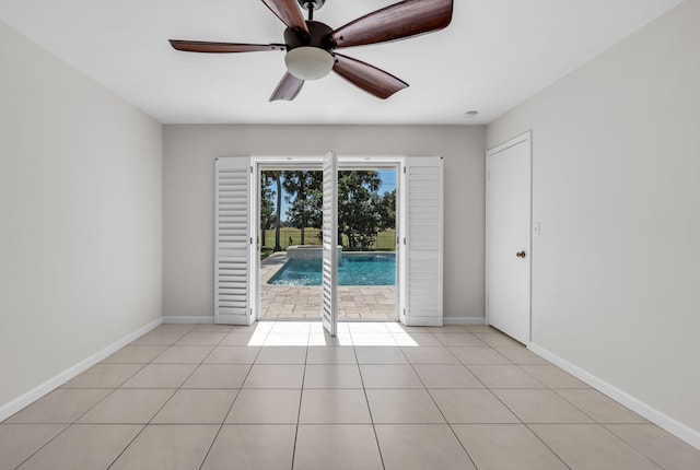 tiled empty room featuring ceiling fan