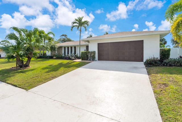 single story home with a garage and a front lawn