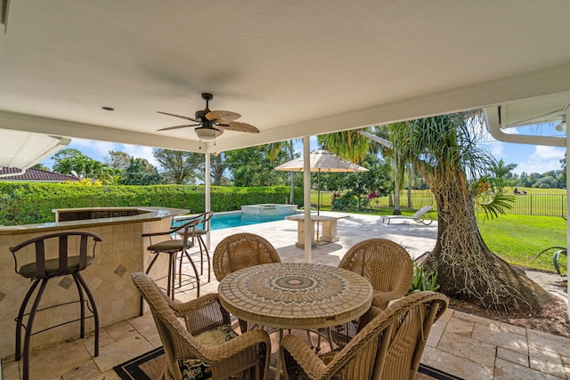 view of patio / terrace with a bar, ceiling fan, and a swimming pool with hot tub