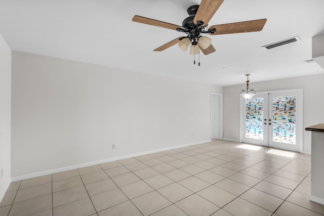 spare room featuring ceiling fan and french doors