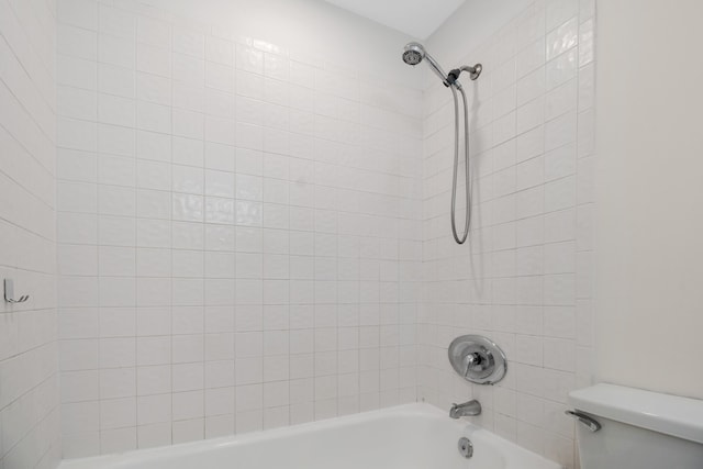 bathroom with toilet and tiled shower / bath combo