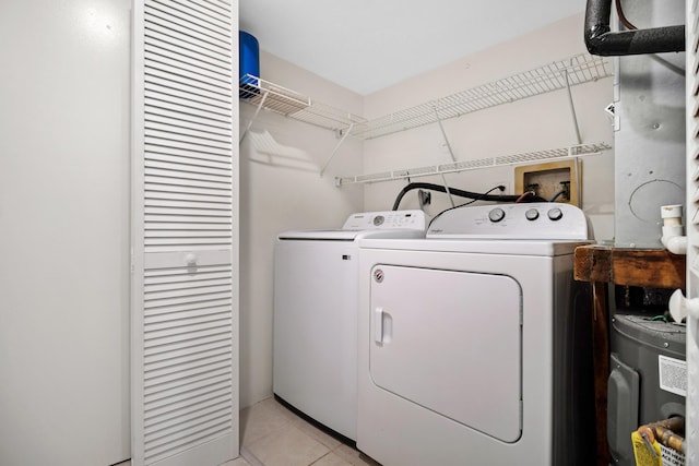 clothes washing area featuring light tile patterned flooring and independent washer and dryer