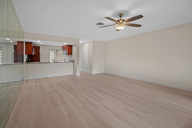 unfurnished living room featuring ceiling fan and light hardwood / wood-style floors