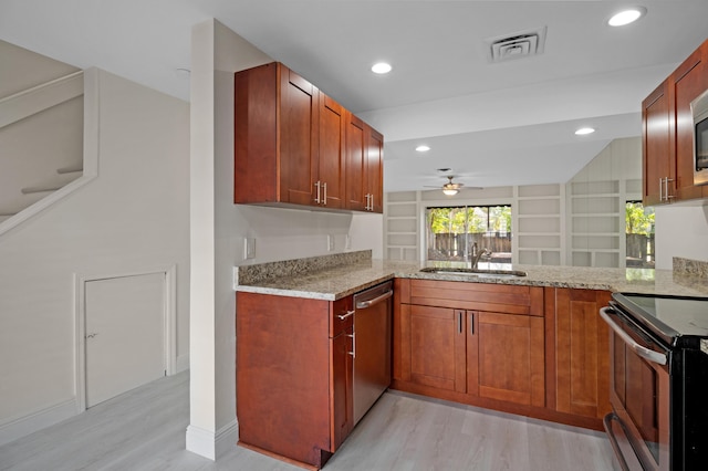 kitchen with sink, light hardwood / wood-style floors, kitchen peninsula, stainless steel appliances, and light stone countertops