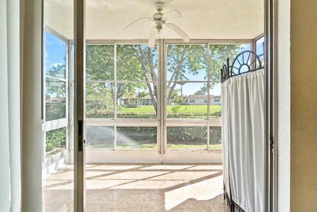 unfurnished sunroom featuring a healthy amount of sunlight and ceiling fan