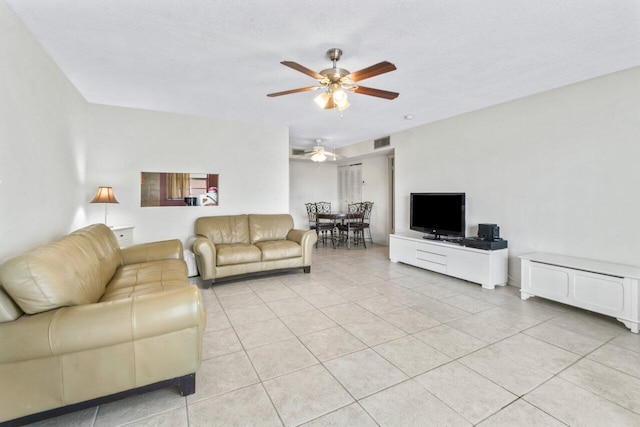 tiled living room with ceiling fan and a textured ceiling