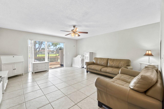 living room featuring ceiling fan, light tile patterned floors, and a textured ceiling