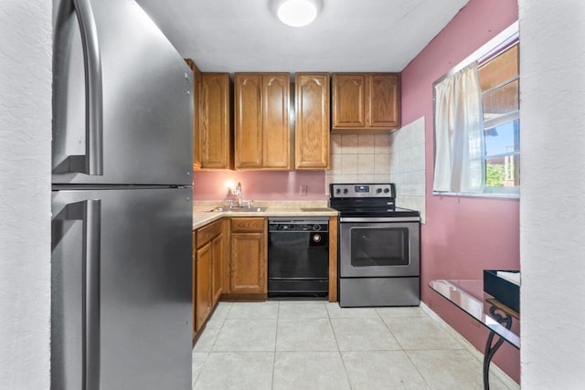 kitchen featuring appliances with stainless steel finishes, sink, light tile patterned floors, and backsplash