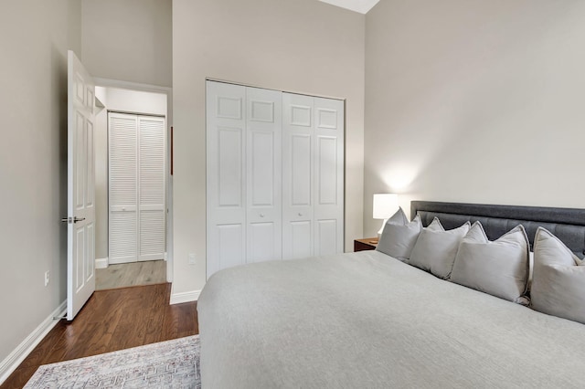 bedroom with a high ceiling, dark hardwood / wood-style floors, and a closet