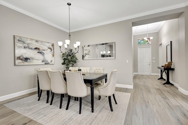 dining room with an inviting chandelier, crown molding, and light wood-type flooring