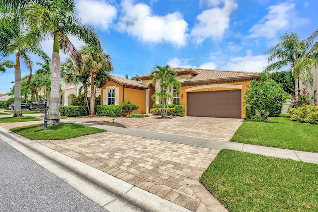 mediterranean / spanish home with a garage and a front yard