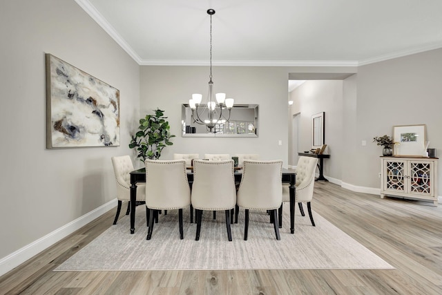 dining space with crown molding, a notable chandelier, and light wood-type flooring