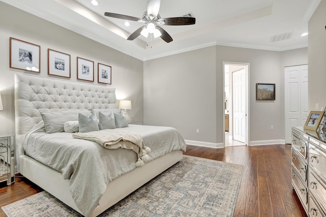 bedroom with crown molding, ceiling fan, dark hardwood / wood-style flooring, and a raised ceiling