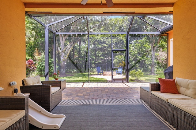 sunroom with ceiling fan and beam ceiling