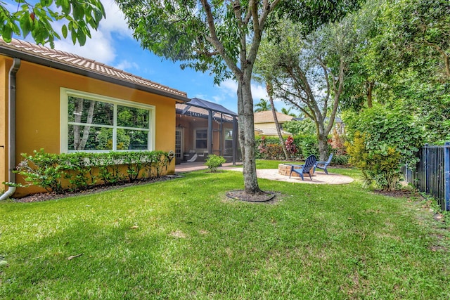 view of yard with an outdoor fire pit, a lanai, and a patio area