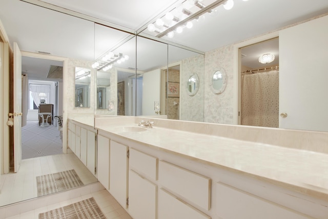 bathroom with tile patterned flooring, vanity, and walk in shower