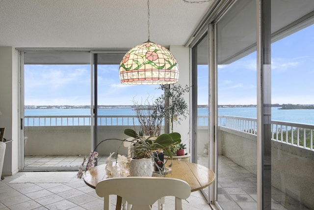 sunroom featuring a water view and a wealth of natural light