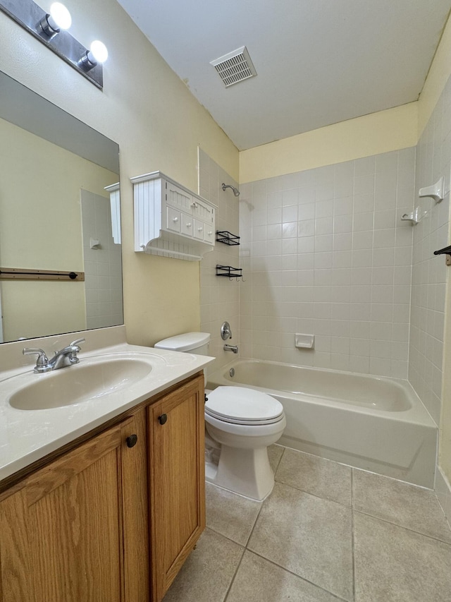 full bathroom featuring tiled shower / bath, vanity, tile patterned floors, and toilet