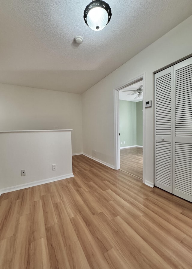 empty room with light hardwood / wood-style floors and a textured ceiling