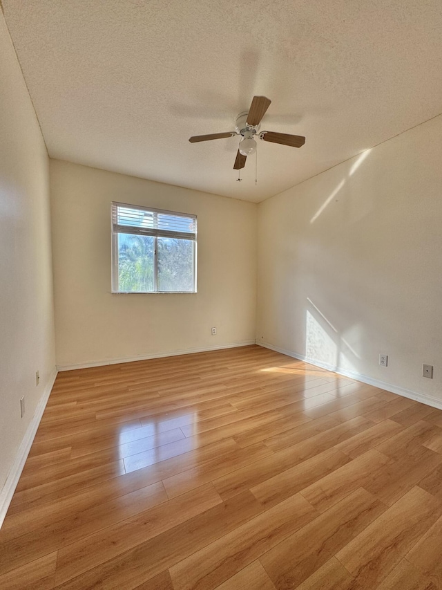 unfurnished room featuring ceiling fan, a textured ceiling, and light wood-type flooring