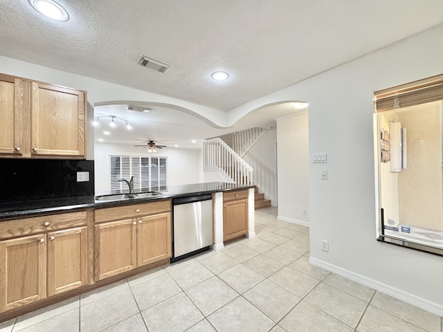 kitchen featuring a textured ceiling, stainless steel dishwasher, ceiling fan, light tile patterned floors, and sink