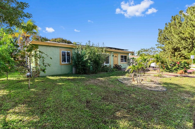 rear view of house featuring a lawn